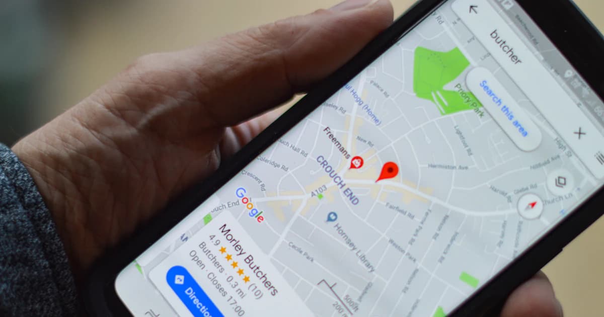 Customer holding a smartphone showing local business results with ratings on Google Maps