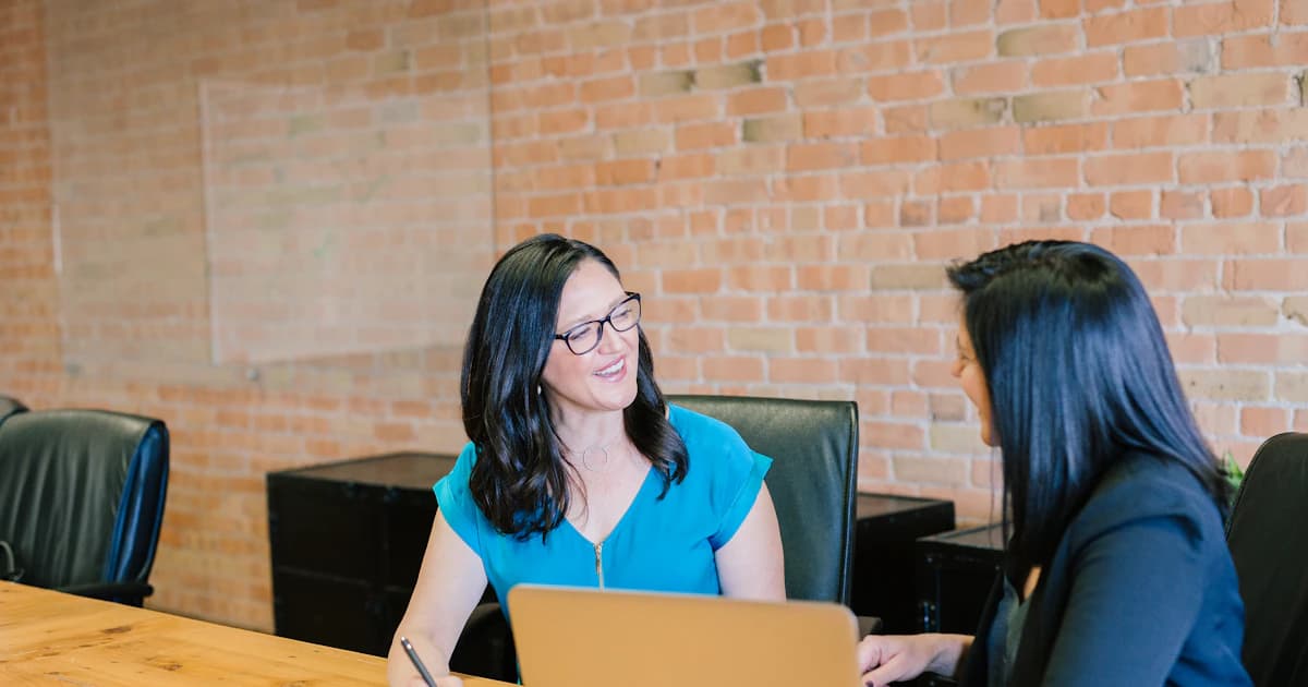 Business owner discussing marketing strategy with an agency consultant over a laptop